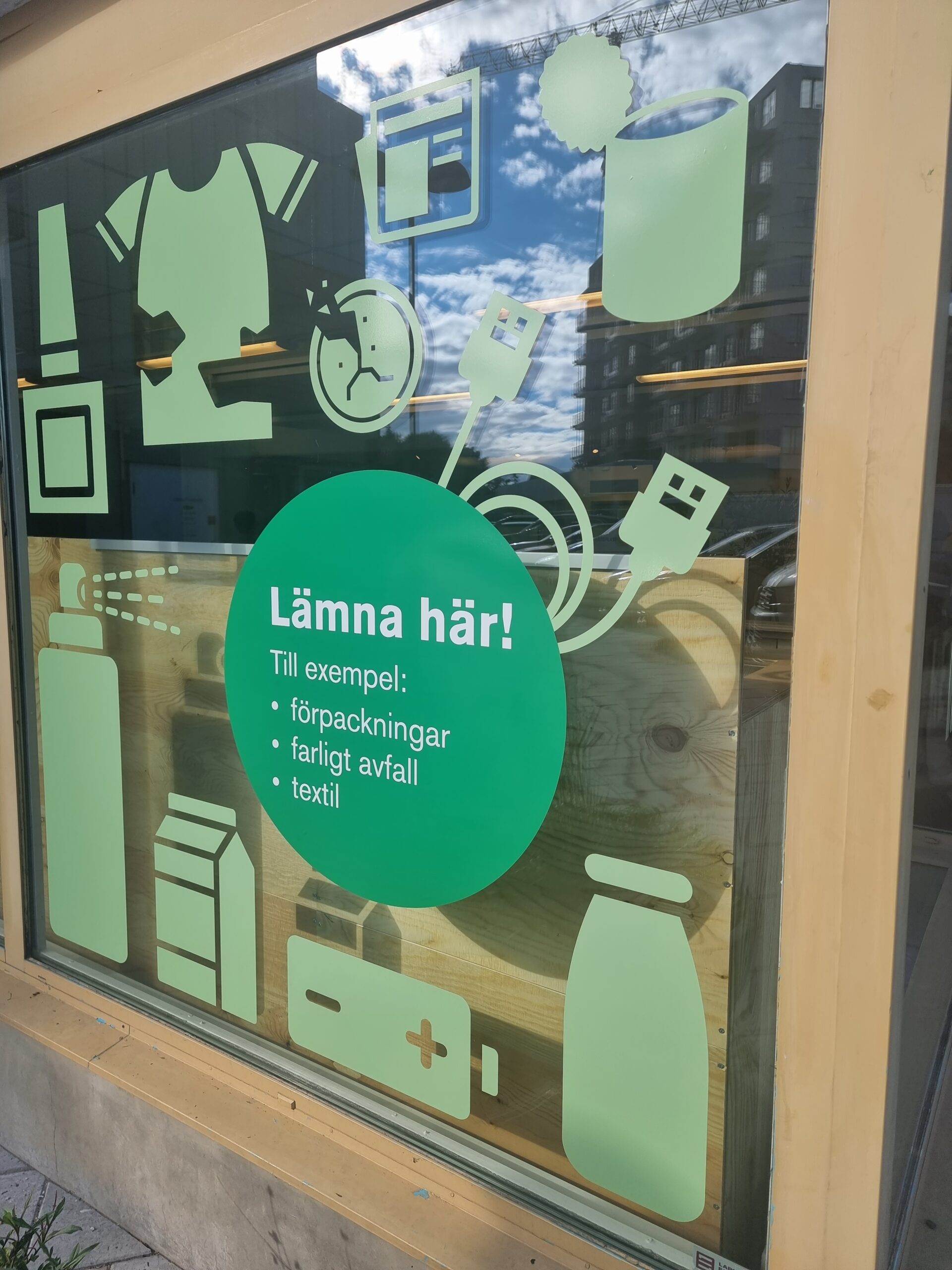 Skyltfönster på Returpunkten Solna med grafisk profilering för återlämning av förpackningar och farligt avfall